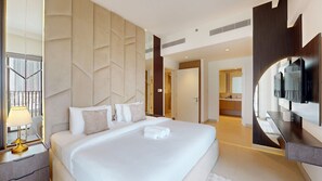 Ein modernes Hotelzimmer mit einem großen Bett, einem Fernseher, einem Badezimmer und Blick auf die Stadt.