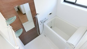 A bathroom with a bathtub, a mirror, and a shower. - EASE Takasaki Toyooka (Takasaki)