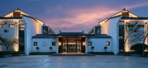 A modern hotel entrance with a symmetrical facade, a central entrance, and a landscaped courtyard. - Deqing Radisson Manor (Huzhou)