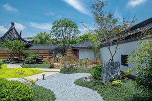 A traditional courtyard with a pathway leading to a building with a tiled roof. - Deqing Radisson Manor (Huzhou)