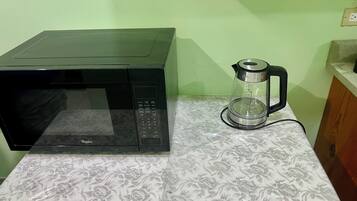 Eine Mikrowelle und eine Kaffeemaschine auf einer gemusterten Arbeitsplatte.