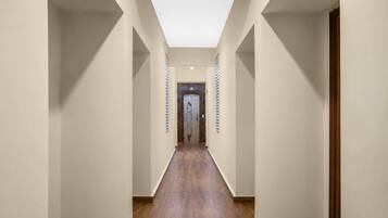 A long, narrow hallway with a skylight ceiling and wooden flooring.
