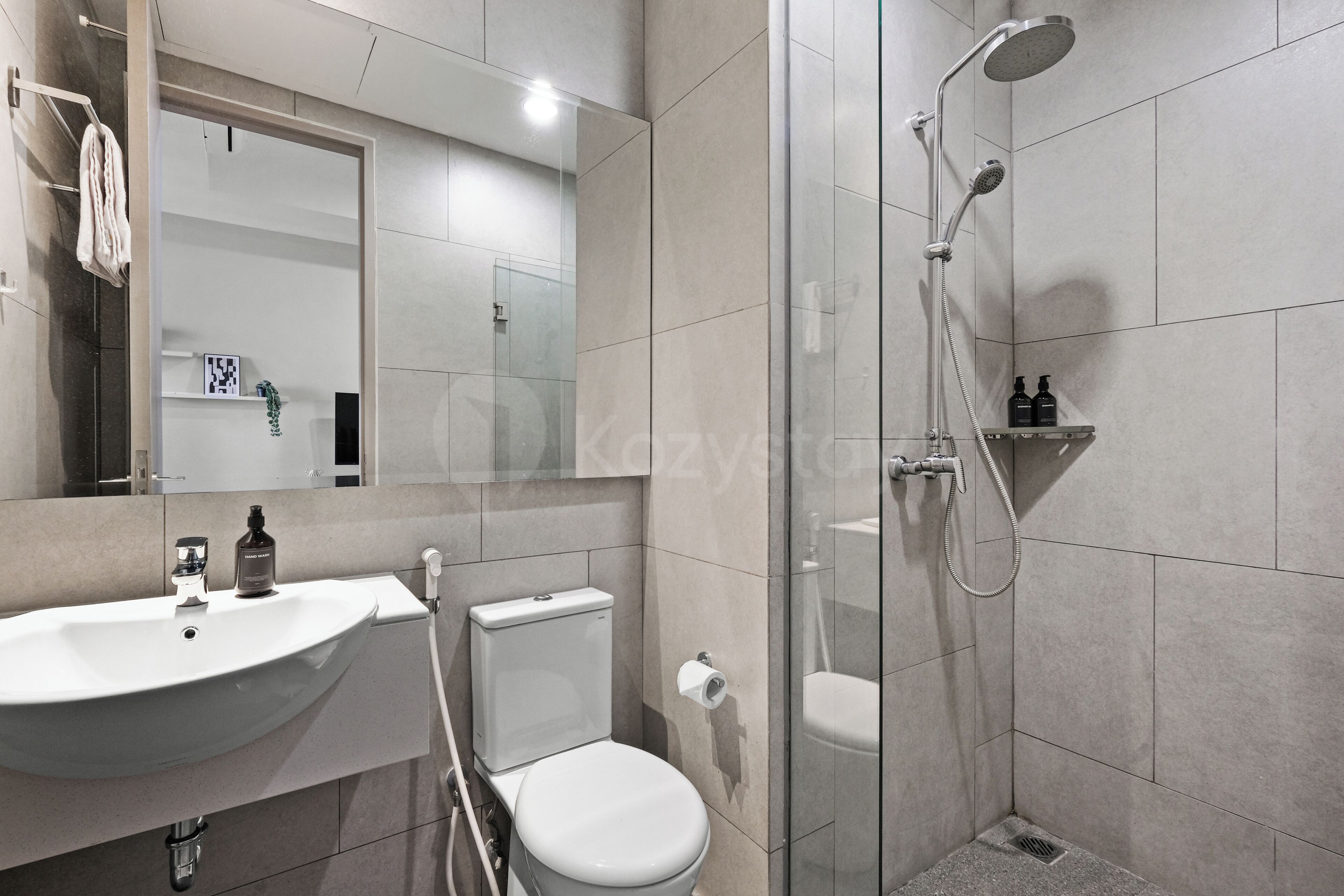 A modern bathroom with a sink, toilet, and glass-enclosed shower.