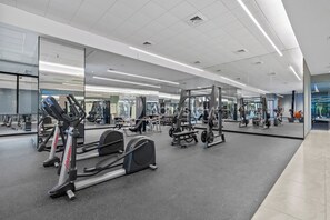 Ein modernes Fitnessstudio mit Cardiogeräten, Krafttrainingsgeräten und Spiegeln an den Wänden.