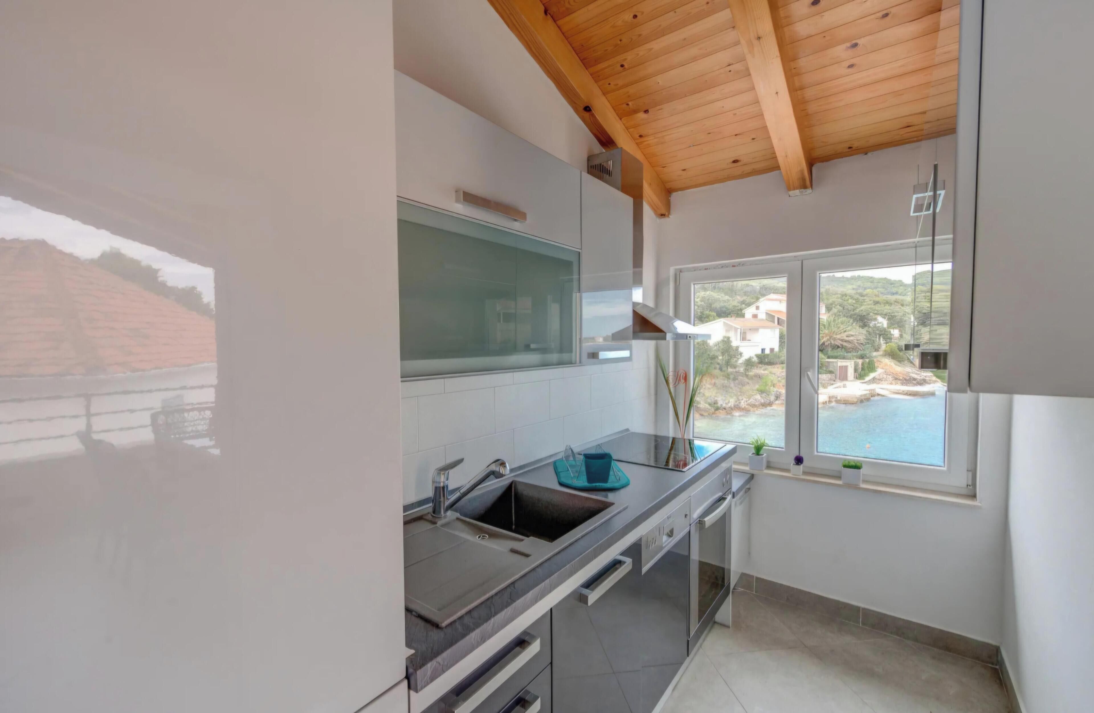 A modern kitchen with a built-in oven, a sink, and a window overlooking a scenic view.