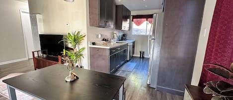 Cozinha moderna com armários escuros, geladeira e micro-ondas.
