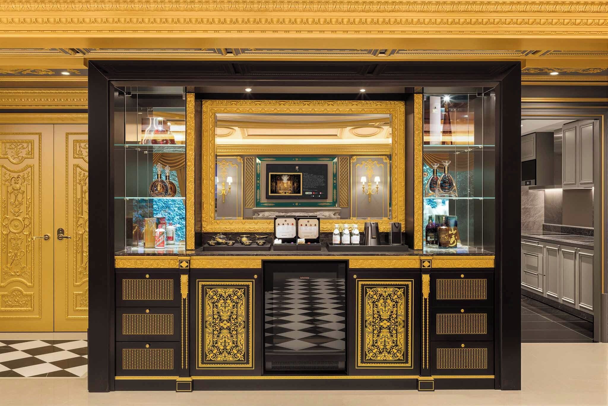 A luxurious bar area with ornate gold detailing, a large mirror, and a chessboard.