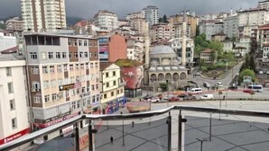 A cityscape with a prominent building featuring a dome and a large mural. - Kaçkar Otel (Rize)
