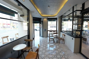 A cafe interior with a tiled floor, wooden chairs, and tables.