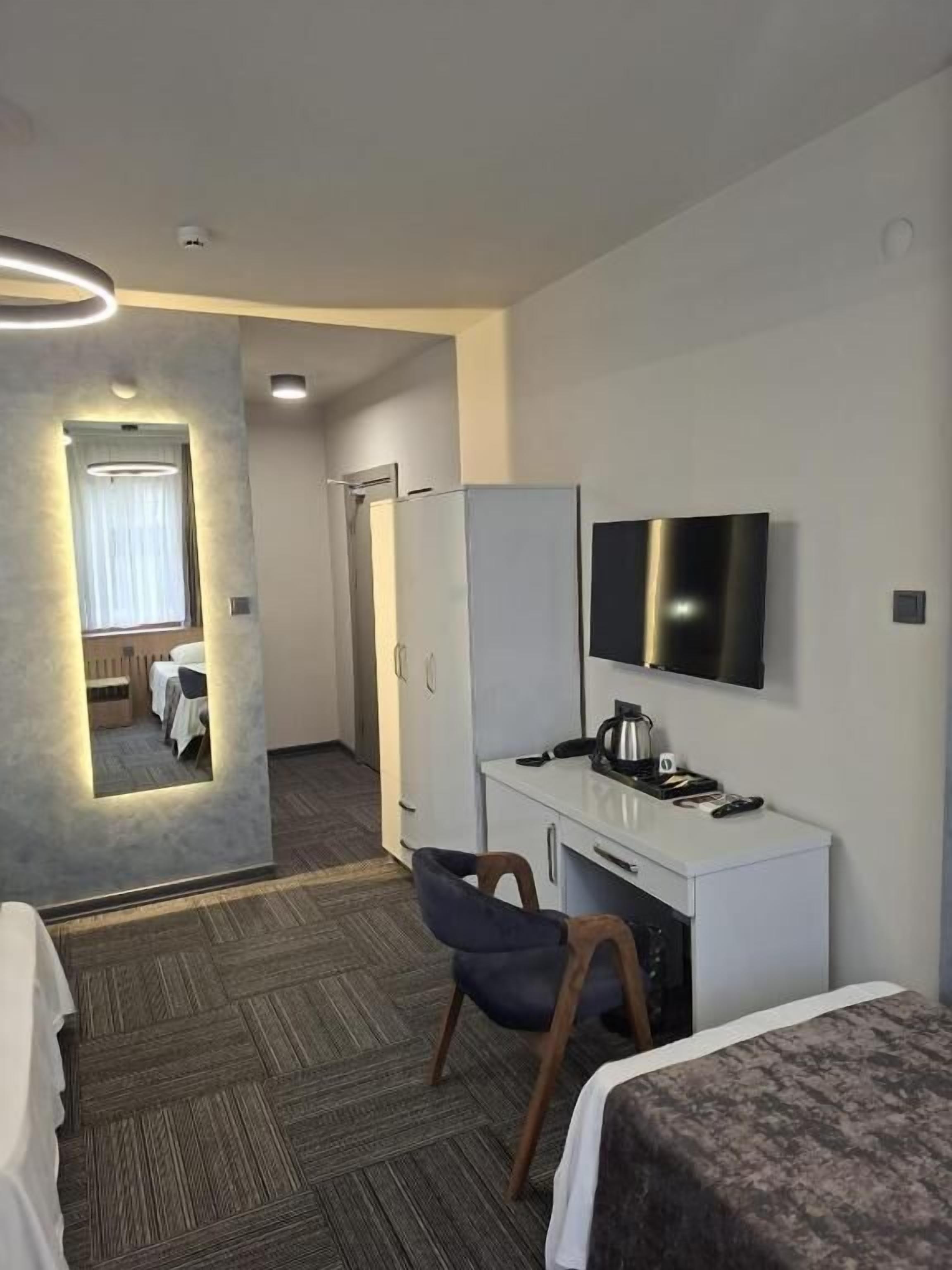 Habitació d'hotel amb escriptori, cadira, televisió i llit.