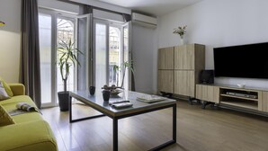 Una sala de estar moderna con un sofá, una mesa de centro, un televisor y un aparador.