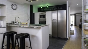Una cocina moderna con una isla integrada, electrodomésticos de acero inoxidable y un reloj en la pared.