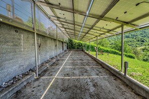 A covered walkway with a grid floor, metal railings, and a view of a green hillside. - Hillside Retreat With Pool & Wellness (Gornja Stubica)