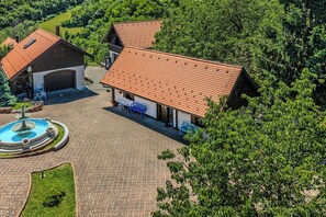 Ein großes Gebäude mit einem Ziegeldach, einem Schwimmbecken und einem Garten.