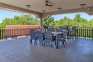 An outdoor patio with a table and chairs, a ceiling fan, and a view of trees. - Hillside Retreat With Pool & Wellness (Gornja Stubica)