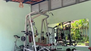 A gym with various exercise equipment, a bench, and a lotus pond.