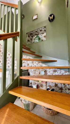 A staircase with wooden steps and a green wall. There are nameplates and a decorative plate on the wall. - AppartCosy 20 Country House Near “Régalante” (Landavran)