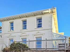 A white building with three windows and a balcony. - Pier View is a seafront property with amazing views and dramatic sunsets. (Pier View)