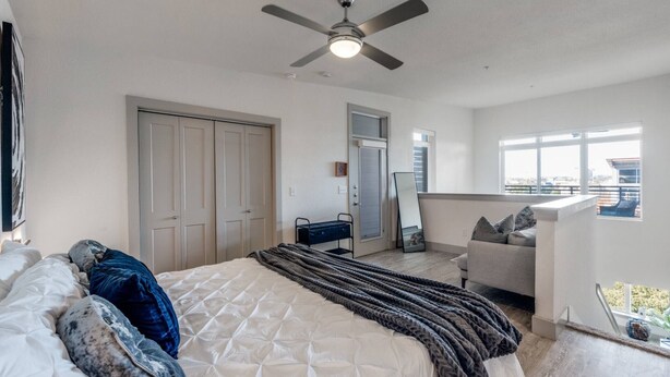 A bedroom with a bed, a ceiling fan, a window, and a balcony. - Riverwalk Penthouse Skyline Views  RSV Parking Pet Friendly Free parking (San Antonio)