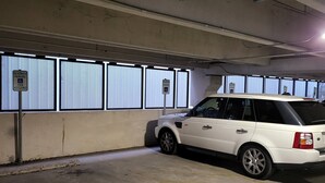 A parking garage with a white SUV parked in a reserved spot. - Riverwalk Penthouse Skyline Views  RSV Parking Pet Friendly Free parking (San Antonio)