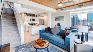 A modern living room with a staircase, a kitchen, and a dining area. - Riverwalk Penthouse Skyline Views  RSV Parking Pet Friendly Free parking (San Antonio)
