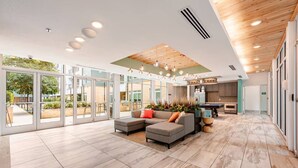 A spacious living area with a sectional sofa, a kitchen in the background, and large glass doors leading to an outdoor patio. - Riverwalk Penthouse Skyline Views  RSV Parking Pet Friendly Free parking (San Antonio)