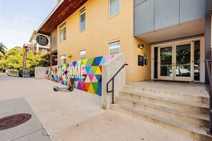 A building with a colorful geometric wall and a sign reading '120 Ninth Street.' - Riverwalk Downtown Luxury Pool & Free Parking (San Antonio)