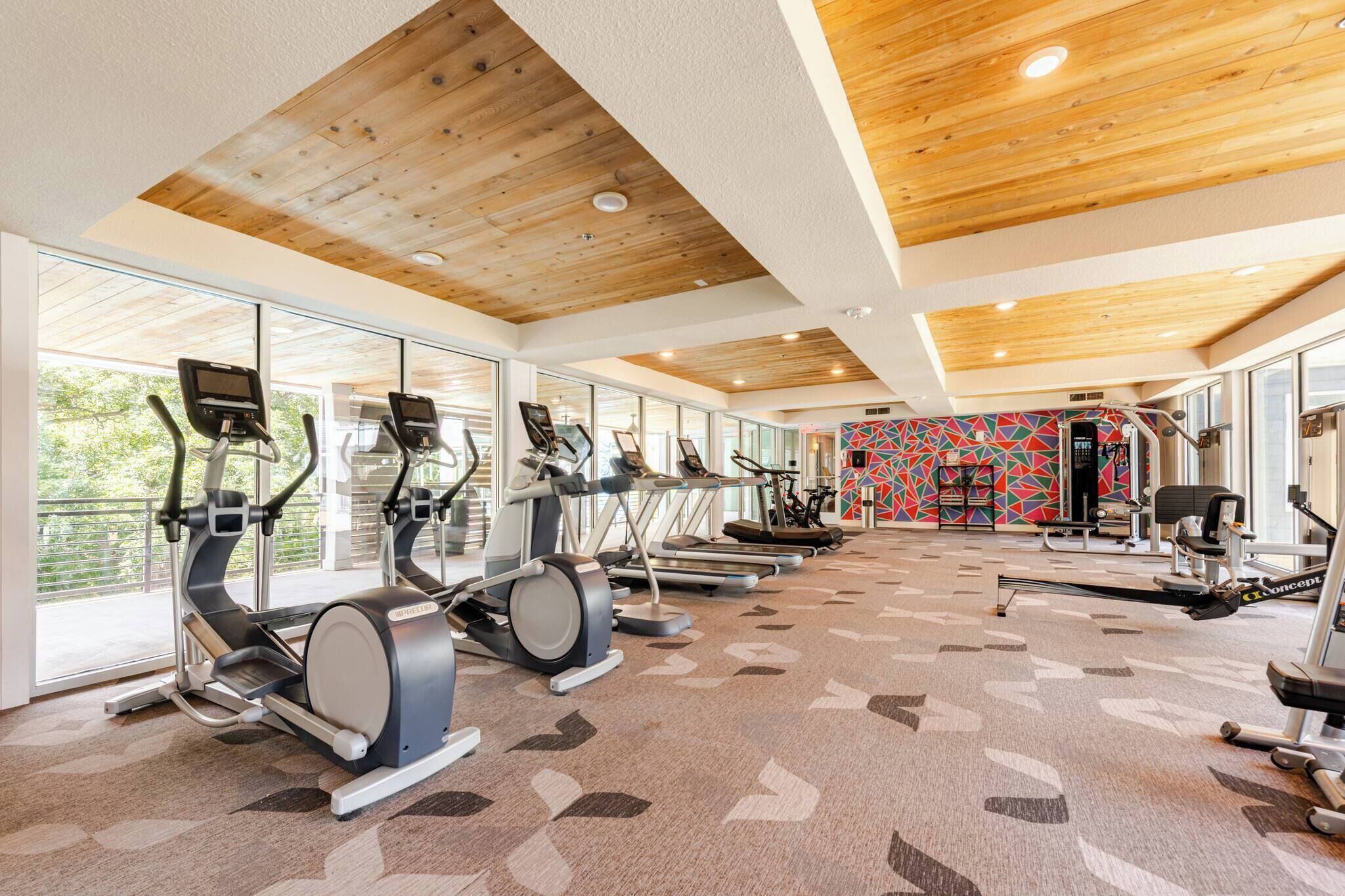 Une salle de sport équipée de tapis de course, de vélos d’appartement et d’appareils de musculation.
