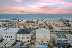 A coastal hotel with multiple buildings, a parking lot, and a swimming pool. - Walk to Beach • Shared Pool + Hot Tub • Near St. Andrews | Low Tide (Panama City Beach)