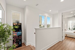 A modern room with a bed, a window, a door, and a vending machine. - Walk to Beach • Shared Pool + Hot Tub • Near St. Andrews | Low Tide (Panama City Beach)
