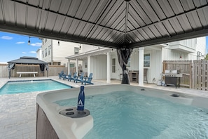 A backyard with a hot tub, a pool, and outdoor furniture. - Walk to Beach • Shared Pool + Hot Tub • Near St. Andrews | Low Tide (Panama City Beach)
