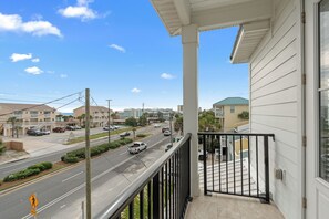 A balcony with a view of a street, buildings, and a clear sky. - Luxe Beach Retreat • Shared Pool + Hot Tub • Walk to Beach | High Tide (Panama City Beach)