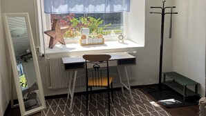 Une pièce comprenant un bureau, une chaise, un radiateur, une fenêtre avec vue et une décoration en forme d’étoile.