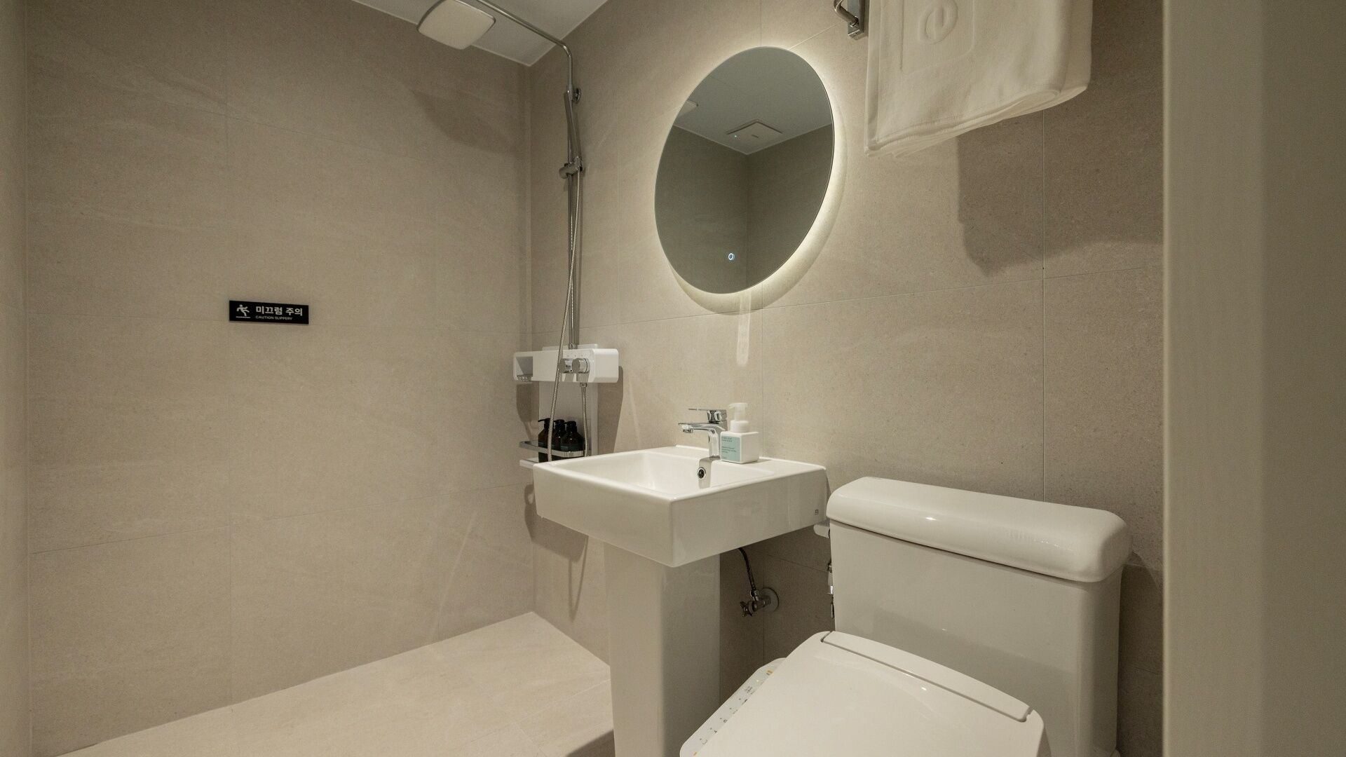 A modern bathroom with a toilet, sink, and a mirror.