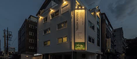 Ein modernes Hotel mit auffälligem Schild, mehreren Etagen und einem gut beleuchteten Eingang.