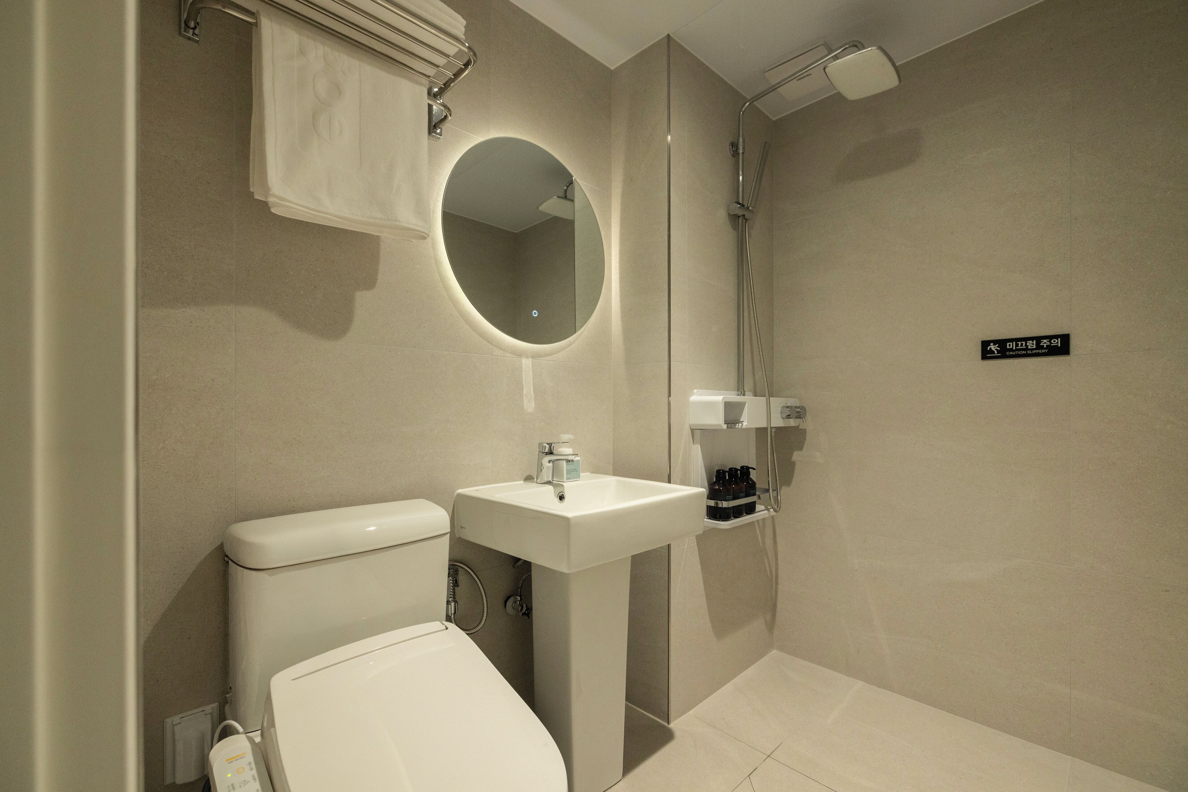 Ein modernes Badezimmer mit Toilette, Waschbecken und Dusche.