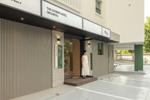 A hotel entrance with a sign reading 'THE COZIEST HOTEL ON EARTH.'