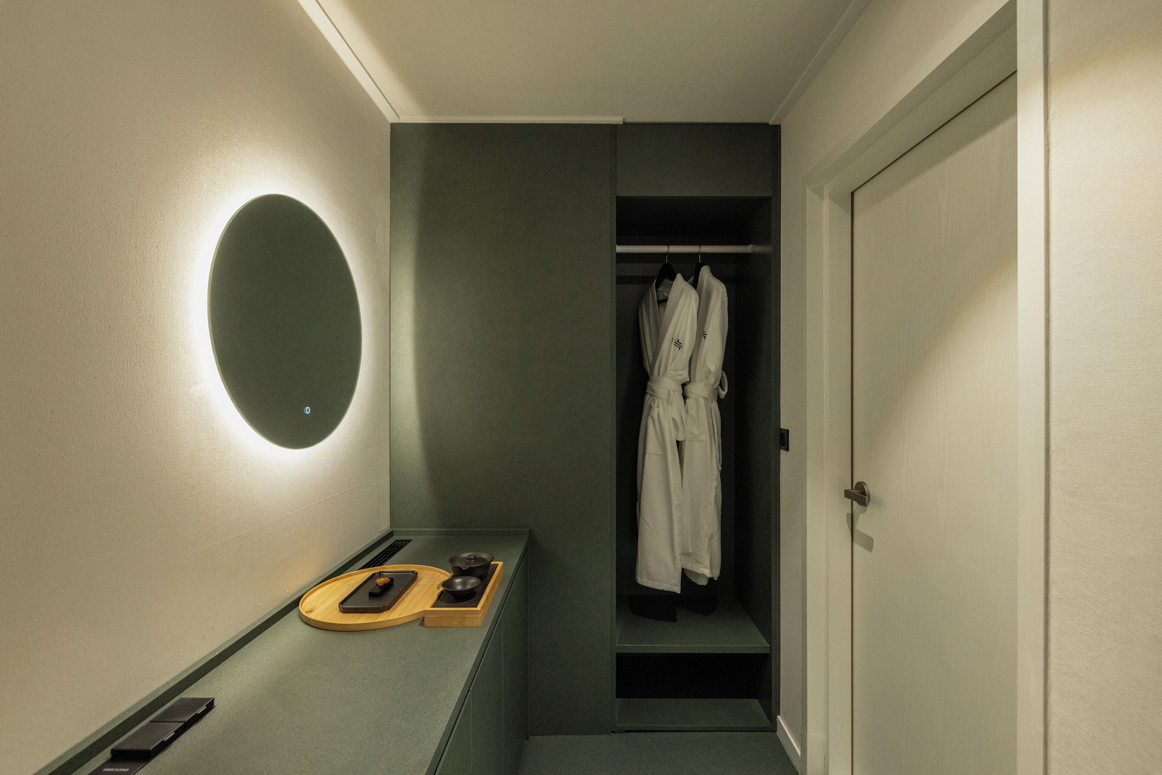 Une salle de bain équipée d’un miroir, d’un porte-serviettes et d’une étagère contenant des articles de toilette.