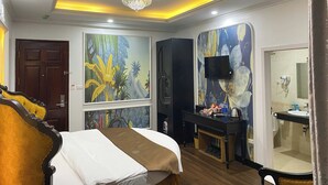 A hotel room with a bed, a desk, a TV, a bathroom, and a ceiling light. - King Luxury Hotel (Tu Liem)