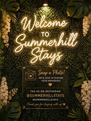A welcome sign for Summerhill Stays with a neon light and a photo request sign. - Stay in the Heart of Atlanta Comfortable, Stylish & Close to Everything (Atlanta)