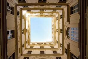 Ein imposantes Atrium mit hoher Decke, aufwendigen architektonischen Details und einer zentralen Oberlichter.