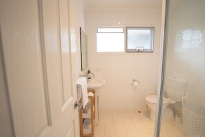A bathroom with a toilet, sink, and window. - Self contained villa, Middleton Rd Cottage (Mira Mar)