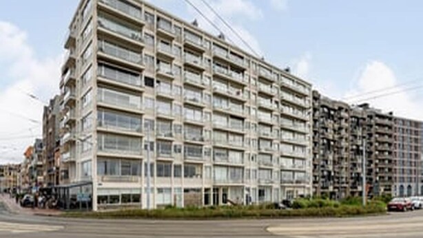 En byggnad med flera våningar, en enhetlig fasad, stora fönster och balkonger.