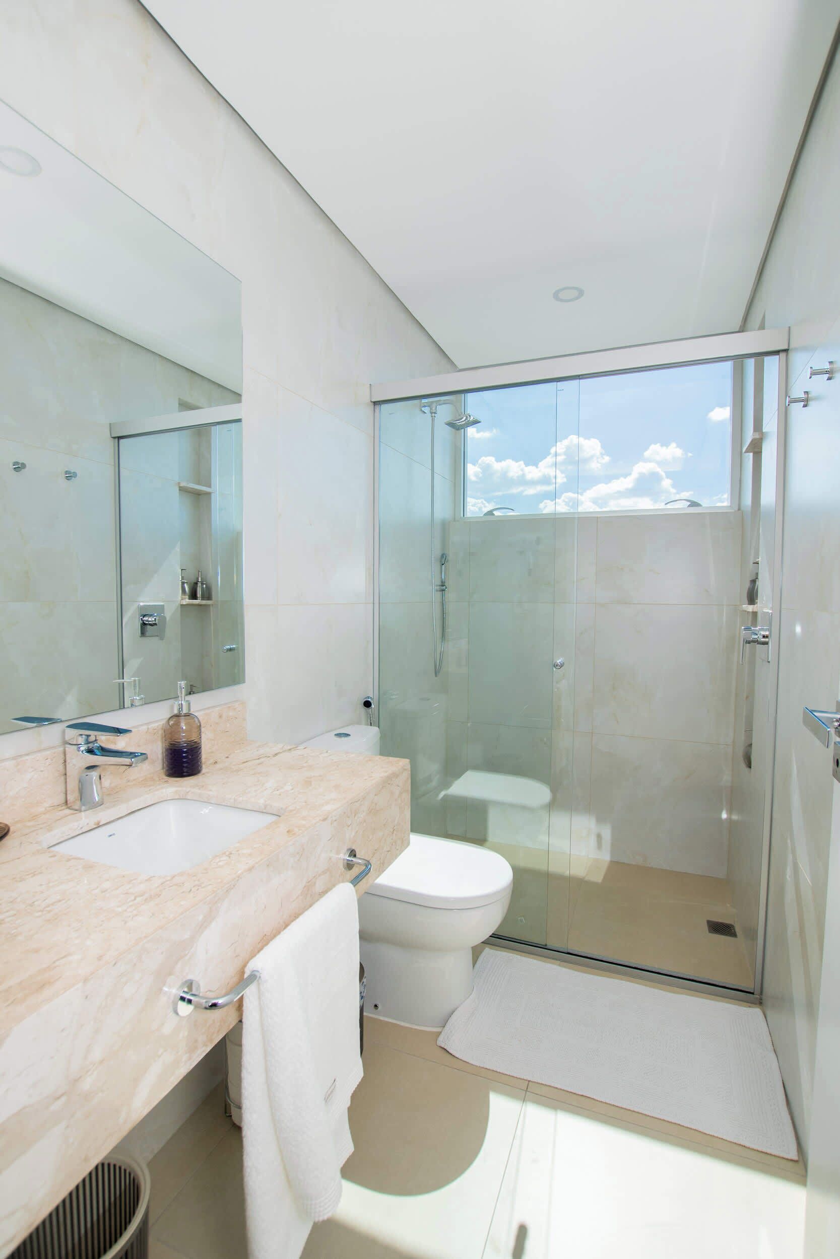 Une salle de bain moderne avec une douche à parois de verre, un lavabo blanc et un grand miroir.