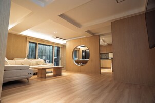Un interior moderno con un sofá, una mesa de centro y un espejo circular.