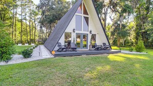 A modern A-frame house with a deck, outdoor seating, and a garden. - Hot Tub, Grill & Fire Pit: Quiet Georgetown Escape (Savannah)