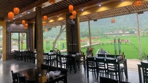 Ein Restaurant mit Außenbereich, Holzbalken und hängenden Laternen.