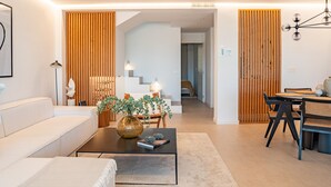 A modern living room with a sofa, coffee table, and a dining area with chairs. - Apartment 'Alexy' with Sea Views, Wi-Fi, and Air Conditioning (Marbella)