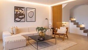 A modern living room with a sofa, coffee table, and a staircase. - Apartment 'Alexy' with Sea Views, Wi-Fi, and Air Conditioning (Marbella)