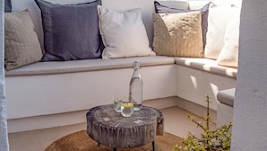 A corner seating area with a round wooden table, a woven rug, and a potted plant. - Apartment 'Alexy' with Sea Views, Wi-Fi, and Air Conditioning (Marbella)